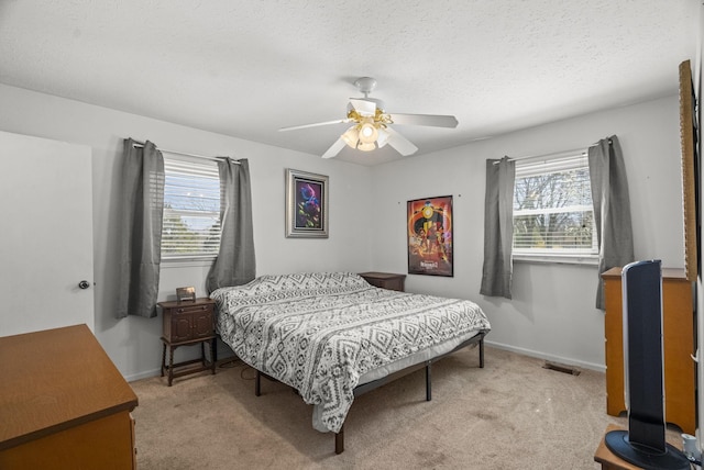 bedroom with carpet floors, baseboards, visible vents, and multiple windows