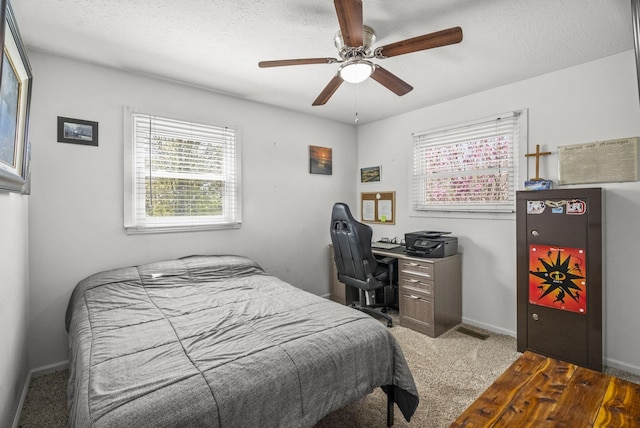 bedroom featuring ceiling fan, a textured ceiling, carpet flooring, and baseboards