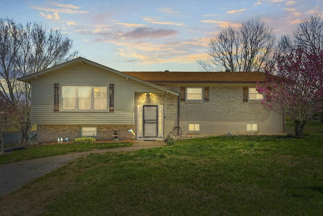 view of front facade with a yard and brick siding