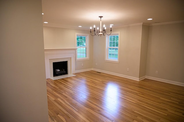 unfurnished living room with crown molding, recessed lighting, baseboards, and an inviting chandelier