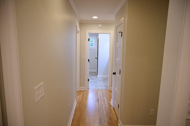 corridor featuring ornamental molding, light wood-style floors, recessed lighting, and baseboards