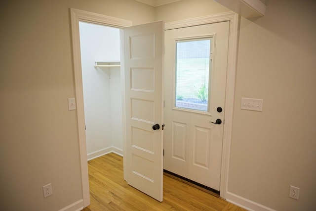 doorway to outside with light wood-style floors and baseboards