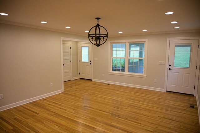 foyer entrance with baseboards, a notable chandelier, ornamental molding, and recessed lighting