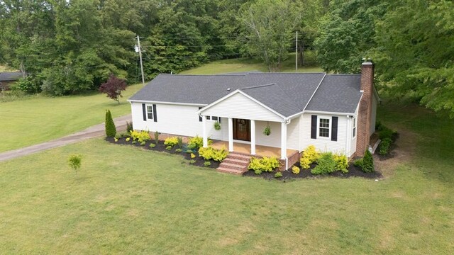 view of front of home featuring a chimney, a front yard, and a porch
