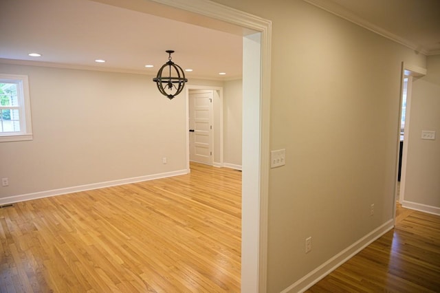 interior space with light wood-type flooring, baseboards, ornamental molding, and recessed lighting