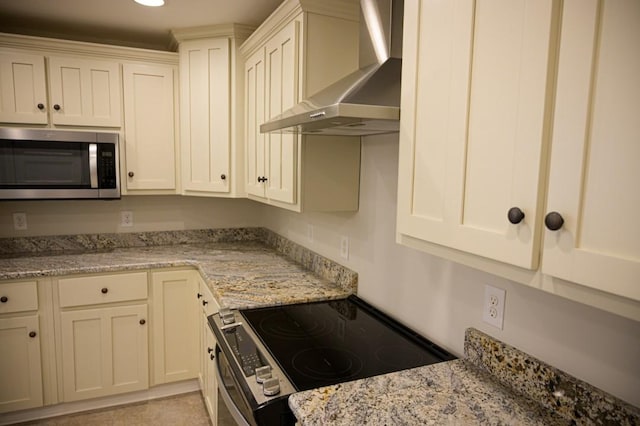 kitchen with wall chimney range hood, electric range oven, stainless steel microwave, and light stone countertops