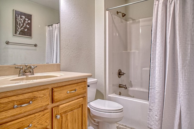 full bath featuring shower / bath combo with shower curtain, toilet, vanity, and a textured wall