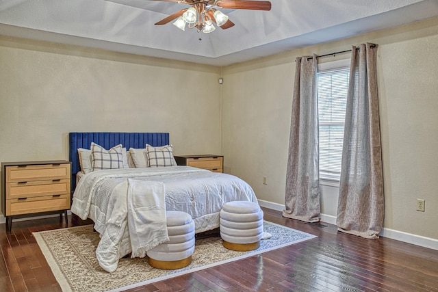 bedroom with baseboards, hardwood / wood-style floors, and a ceiling fan