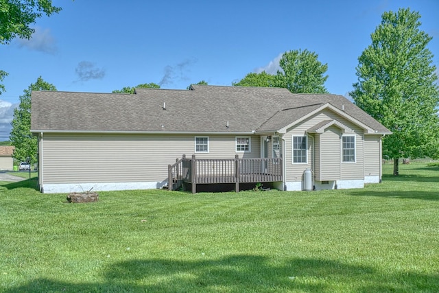 rear view of property with a yard, roof with shingles, and a wooden deck