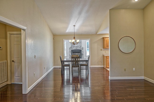 dining space featuring vaulted ceiling, an inviting chandelier, baseboards, and dark wood-type flooring