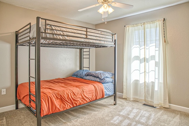 bedroom featuring carpet flooring, visible vents, baseboards, and ceiling fan
