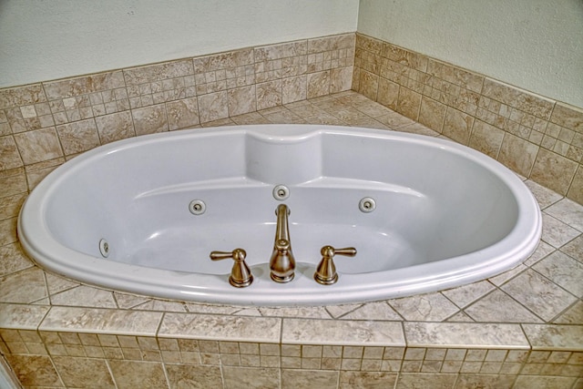 details with a jetted tub and a textured wall