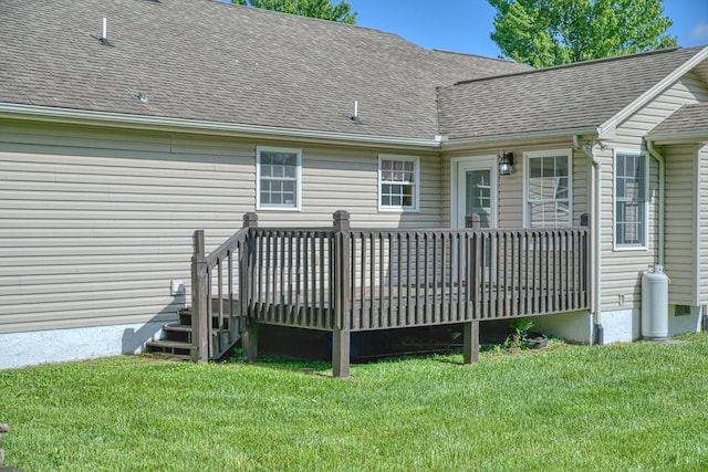 rear view of house featuring a yard, roof with shingles, and a wooden deck
