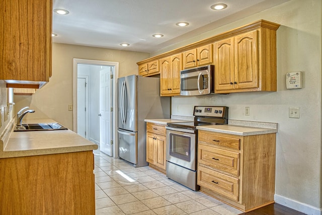 kitchen with light countertops, stainless steel appliances, recessed lighting, and a sink