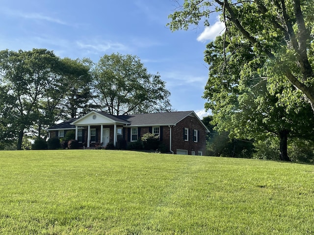 view of front facade with a front yard and brick siding