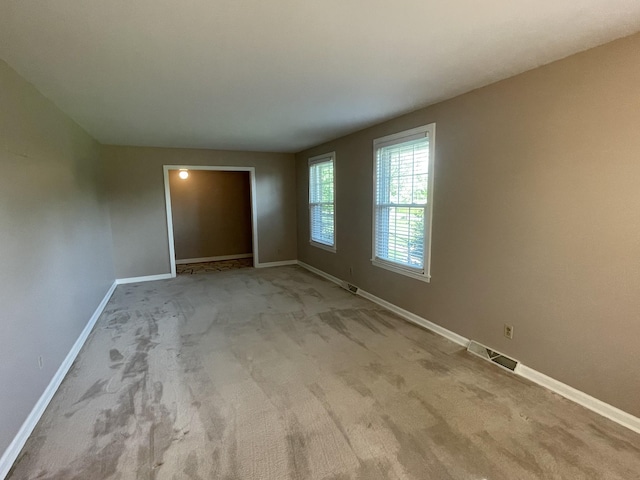 carpeted spare room with baseboards and visible vents