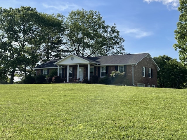 neoclassical / greek revival house featuring covered porch, brick siding, and a front lawn