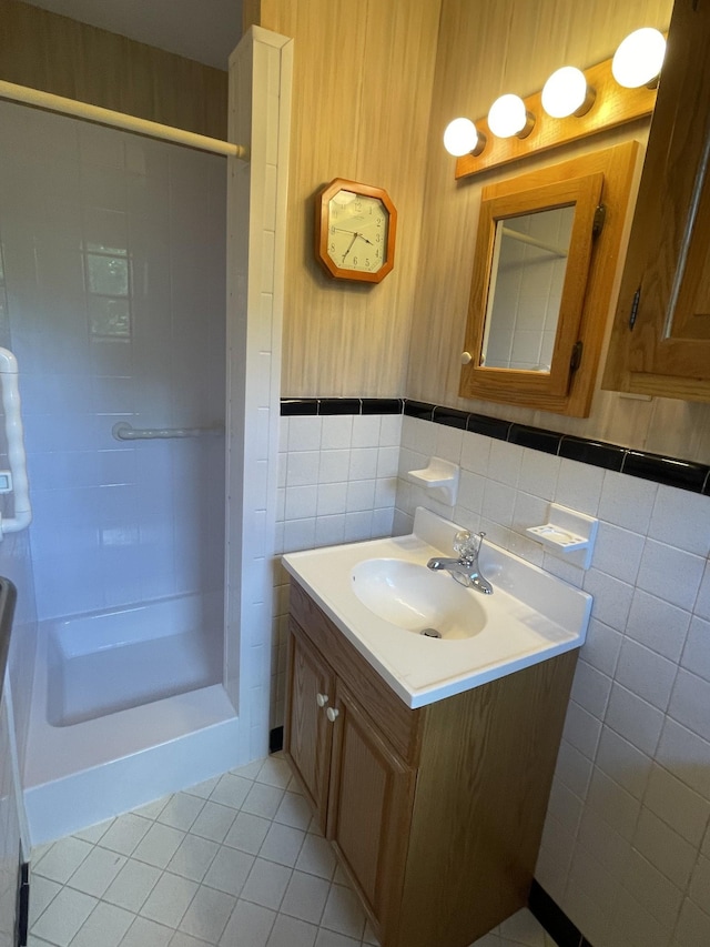 bathroom with walk in shower, tile walls, tile patterned flooring, and vanity