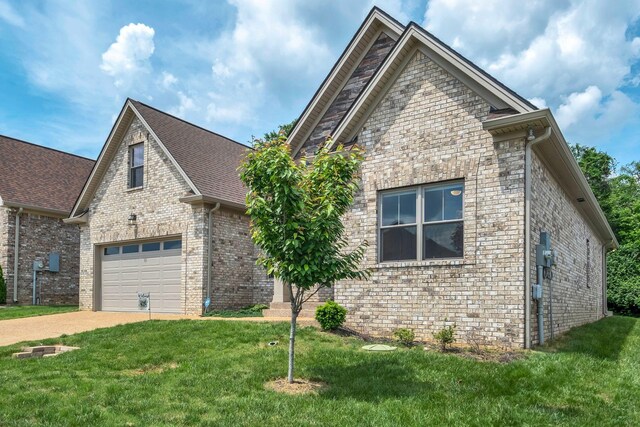 view of front facade with concrete driveway, brick siding, a garage, and a front lawn