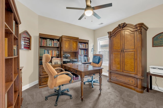 office with baseboards, ceiling fan, dark colored carpet, and visible vents