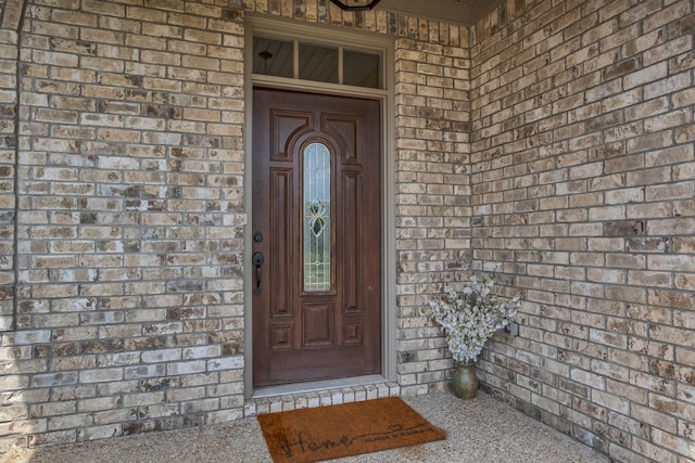 doorway to property featuring brick siding