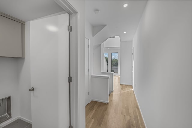 hall featuring light wood-style floors, baseboards, and recessed lighting