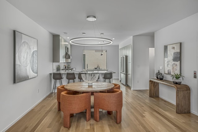 dining room featuring baseboards and light wood-type flooring