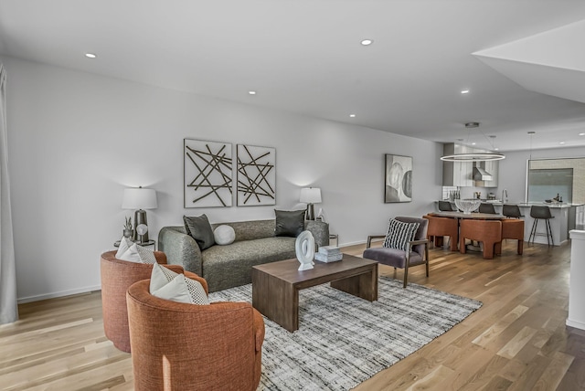 living area with light wood finished floors, baseboards, and recessed lighting