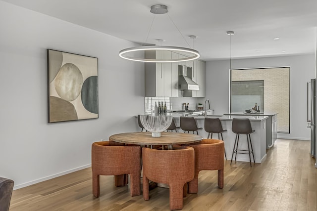 dining space featuring recessed lighting, baseboards, and light wood-style floors