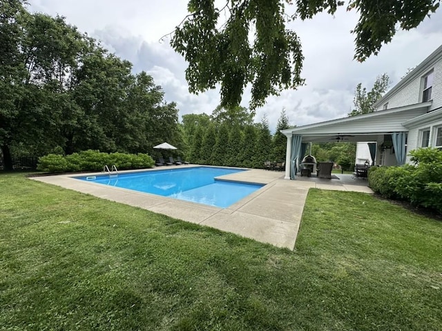 outdoor pool with a yard and a patio