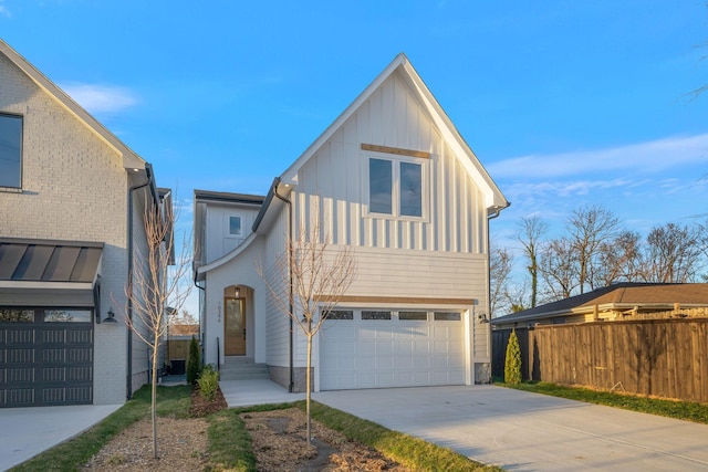view of front of home with an attached garage, board and batten siding, driveway, and fence
