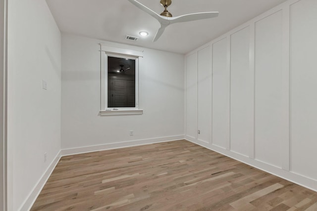 empty room featuring a ceiling fan, baseboards, light wood-type flooring, and visible vents