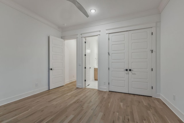 unfurnished bedroom with ornamental molding, a closet, and light wood-style flooring