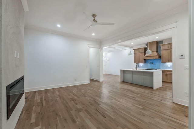 unfurnished living room featuring baseboards, light wood-type flooring, a ceiling fan, and heating unit