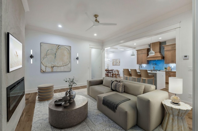 living room with recessed lighting, baseboards, a glass covered fireplace, ceiling fan, and wood finished floors