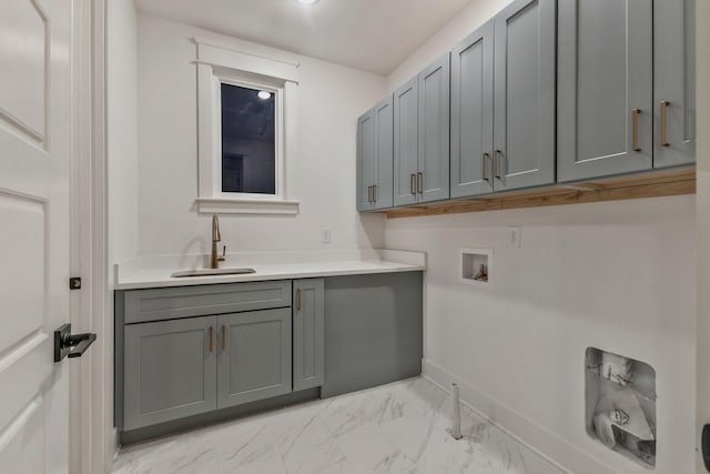 clothes washing area with baseboards, marble finish floor, hookup for a washing machine, a sink, and cabinet space