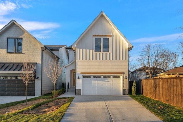 view of front of home featuring driveway, an attached garage, fence, and board and batten siding