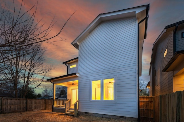back of property at dusk featuring a fenced backyard and crawl space