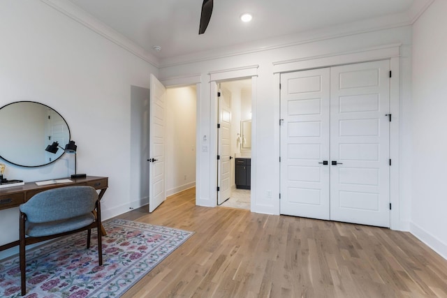 office with baseboards, light wood-style floors, crown molding, and a ceiling fan