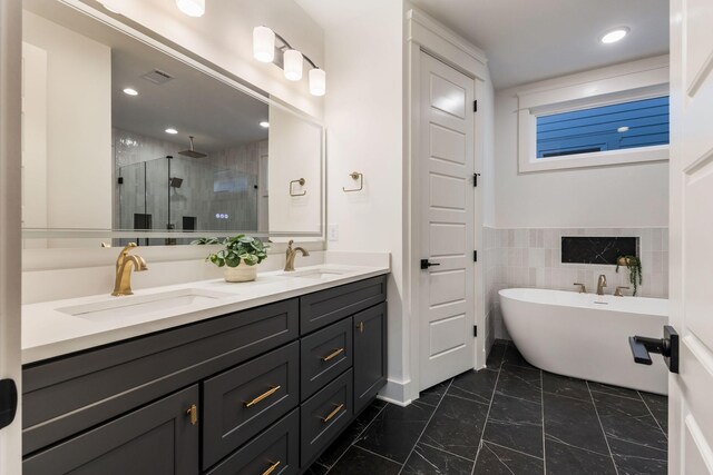 bathroom featuring a shower stall, marble finish floor, double vanity, and a sink