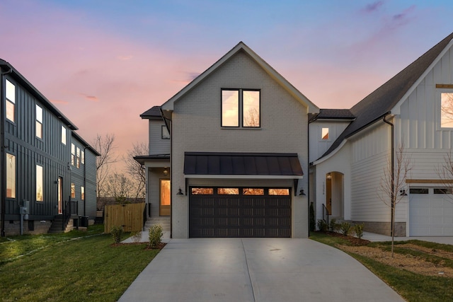 modern farmhouse featuring board and batten siding, driveway, a standing seam roof, brick siding, and an attached garage