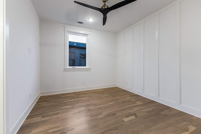 empty room with baseboards, ceiling fan, visible vents, and wood finished floors