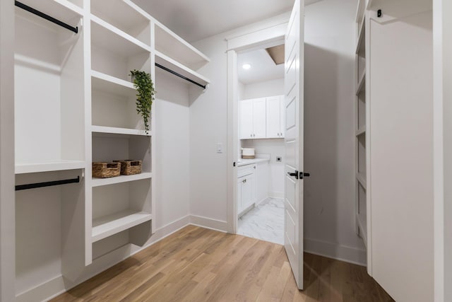 walk in closet with light wood-type flooring
