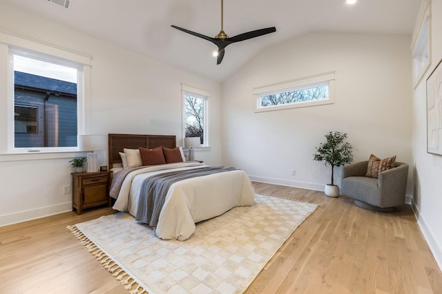 bedroom with vaulted ceiling, baseboards, and wood finished floors