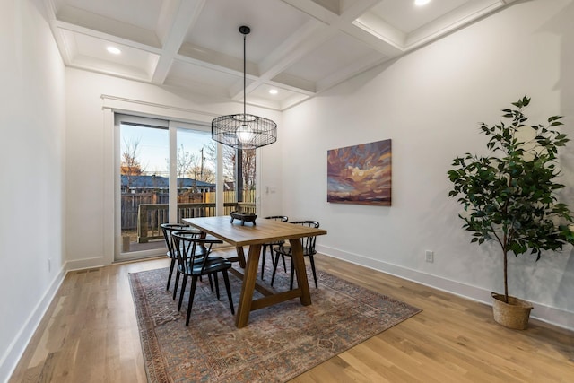 dining space with baseboards, beamed ceiling, and wood finished floors