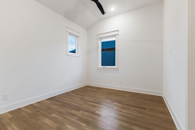 spare room featuring ceiling fan, lofted ceiling, baseboards, and wood finished floors