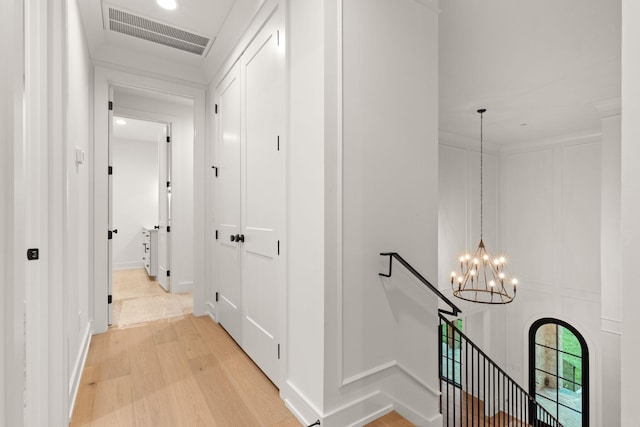 hall with light wood finished floors, an upstairs landing, visible vents, a chandelier, and recessed lighting