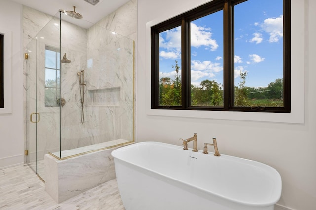 bathroom with a soaking tub, a marble finish shower, baseboards, and a healthy amount of sunlight