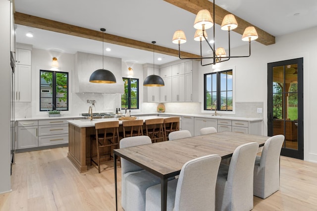 dining space featuring recessed lighting, light wood-style flooring, beam ceiling, and a chandelier
