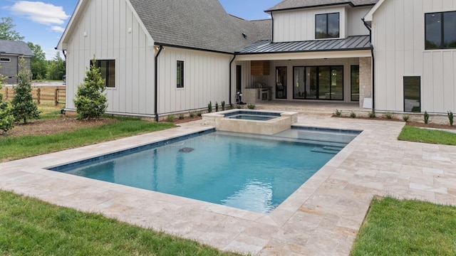 back of property featuring a patio area, metal roof, board and batten siding, a shingled roof, and a standing seam roof
